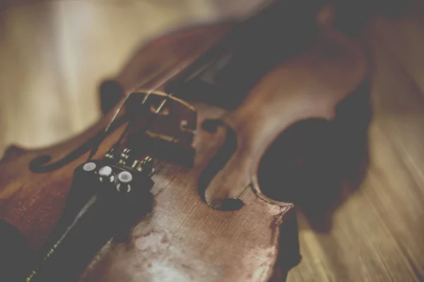 Old violin lying on a wooden surface — Stock Photo, Image