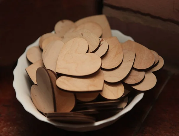 Coeurs en bois sculptés sur une assiette blanche . — Photo