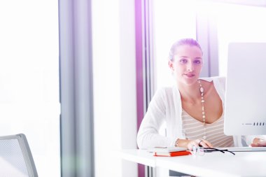 Çekici ofis çalışanı masada oturuyor.