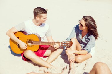 Sahilde gitar ile güzel gençler