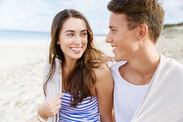 Romantico giovane coppia seduta sulla spiaggia — Foto Stock