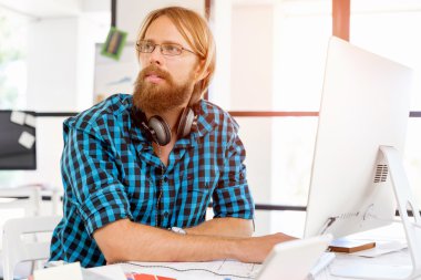 Genç adam ofiste çalışıyor.