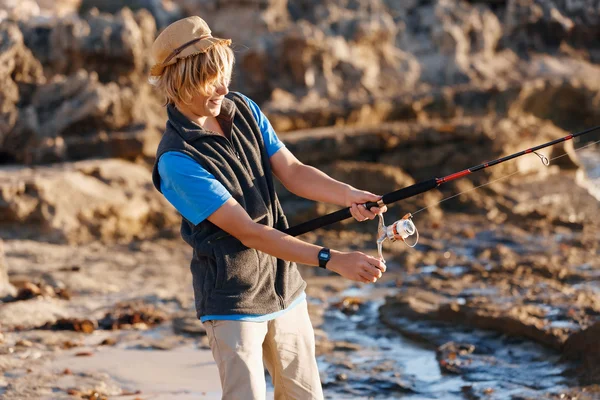 Мальчик-подросток рыбачит в море — стоковое фото