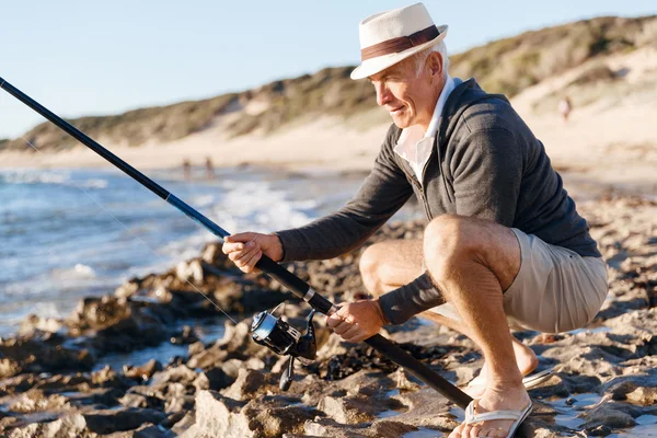 Hombre mayor pescando en el lado del mar —  Fotos de Stock
