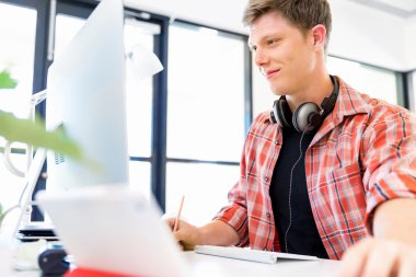 Genç adam ofiste çalışıyor.