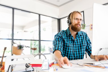 Genç adam ofiste çalışıyor.