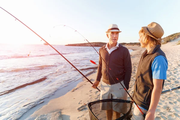 Uomo anziano pesca con suo nipote — Foto Stock