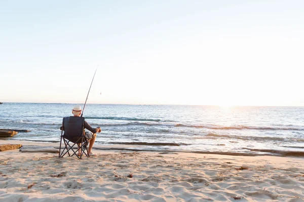 Senior man fishing at sea side — Stock Photo, Image