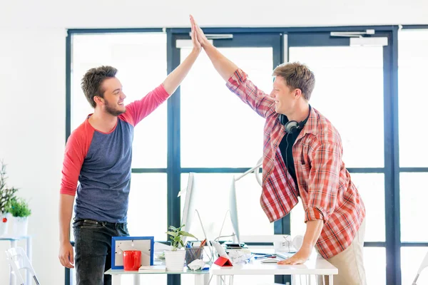 Zwei junge Männer im Büro klatschen in die Hände — Stockfoto