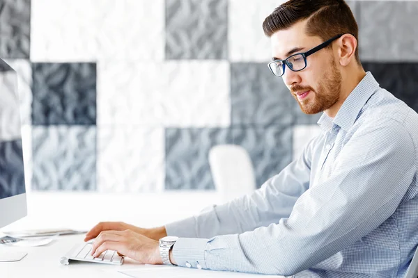 Männliche Büroangestellte sitzt am Schreibtisch — Stockfoto