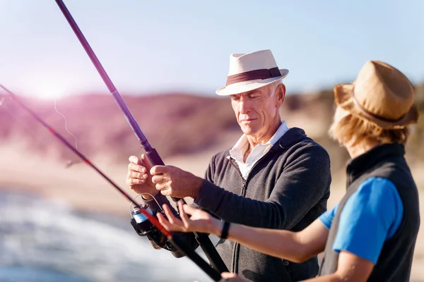 Uomo anziano pesca con suo nipote — Foto Stock