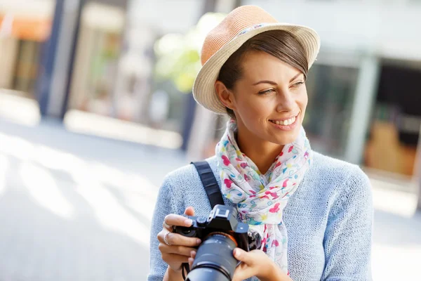 Outdoor summer smiling lifestyle portrait of pretty young woman with camera — Stock Photo, Image