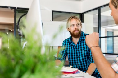 Genç adam ofiste çalışıyor.