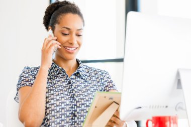 Afro-Amerikan ofis çalışanı iş içinde oturan gülümseyen portresi