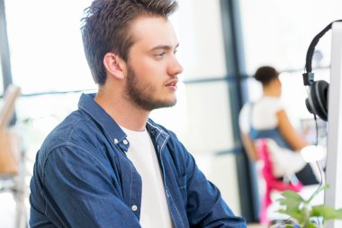 Genç adam ofiste çalışıyor.