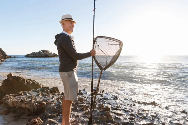 Hombre mayor pescando en el lado del mar — Foto de Stock