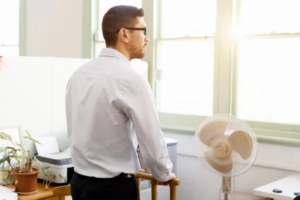 Portrait of young man sitting at the stairs in office — Stock Photo, Image