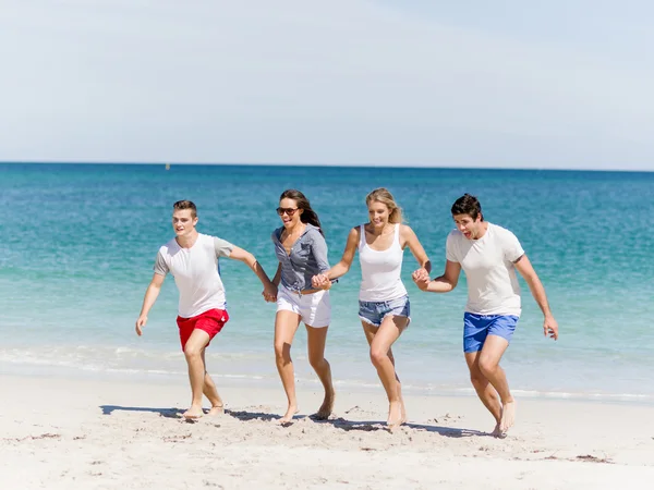 Compañía de jóvenes en la playa — Foto de Stock