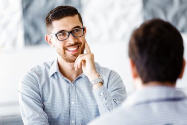 Ofiste iki yakışıklı işadamı var.