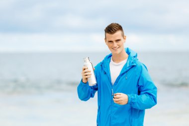 Şişe su ile tutarak kendine güvenen genç adam