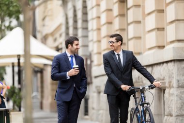 İki genç işadamları ile bir bisiklet şehir merkezinde