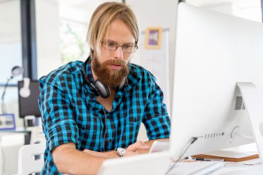 Genç adam ofiste çalışıyor.