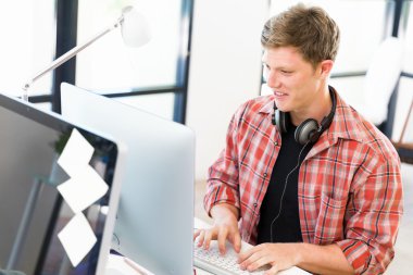 Genç adam ofiste çalışıyor.