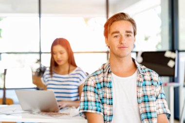 Genç adam ofiste çalışıyor.