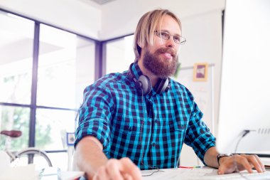 Genç adam ofiste çalışıyor.