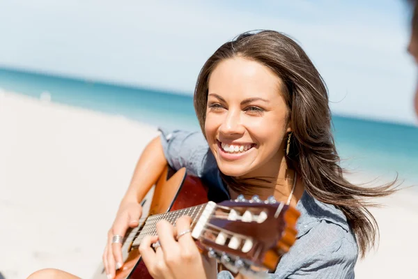 समुद्रकिनारावर गिटार खेळत स्त्री — स्टॉक फोटो, इमेज