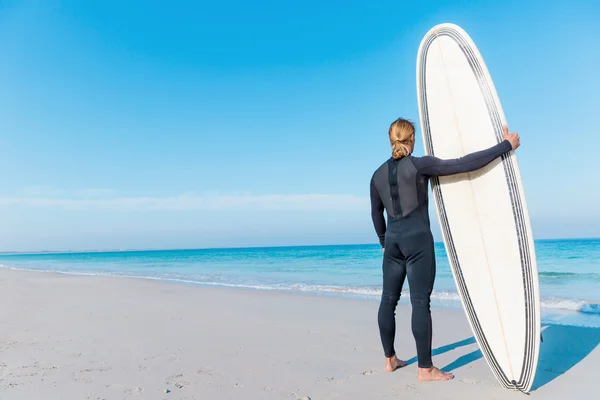 Surfista com sua prancha na praia — Fotografia de Stock