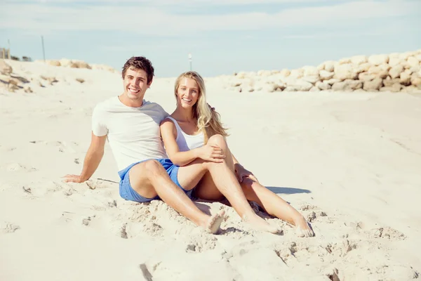 Romantique jeune couple assis sur la plage — Photo