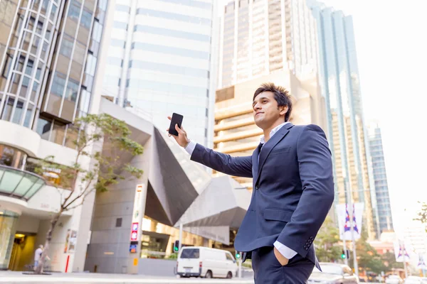 Businessman catching taxi in city — Stock Photo, Image