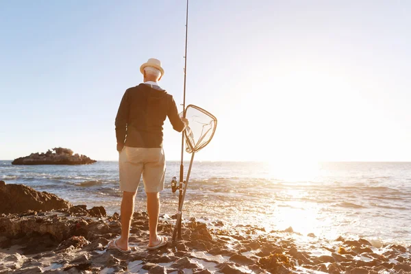 Homem sênior de pesca ao lado do mar — Fotografia de Stock