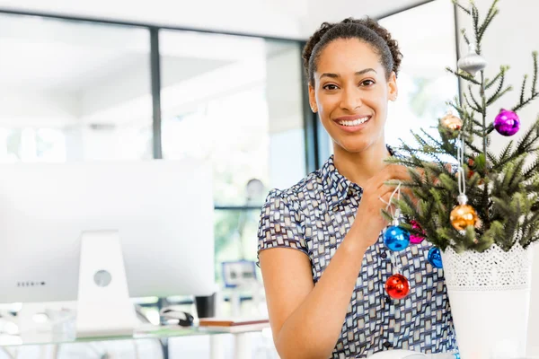 Портрет улыбающегося афро-американского офисного работника, украшающего елку в офисе — стоковое фото