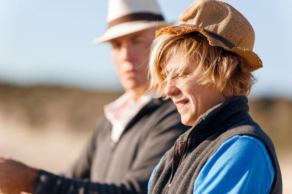 Мальчик-подросток рыбачит в море
