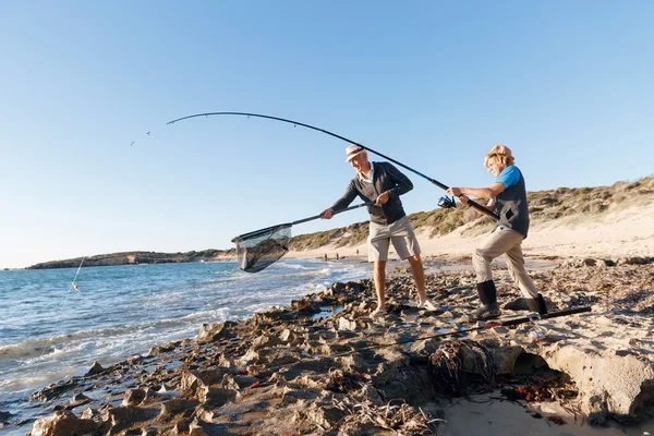 Uomo anziano pesca con suo nipote — Foto Stock