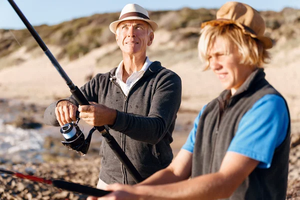 Uomo anziano pesca con suo nipote — Foto Stock