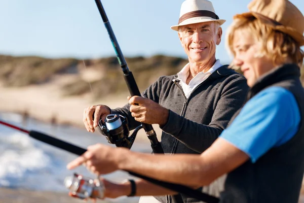 Uomo anziano pesca con suo nipote — Foto Stock