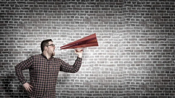 Hipster-Mann schreit in Trompeten. Gemischte Medien — Stockfoto