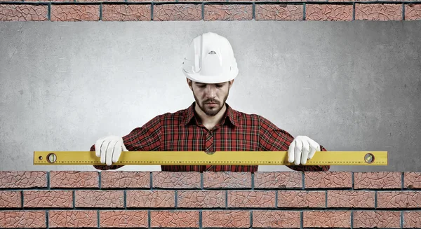 Builder man with level . Mixed media — Stock Photo, Image