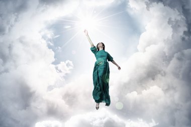 Gökyüzünde levitating kadın. Karışık teknik