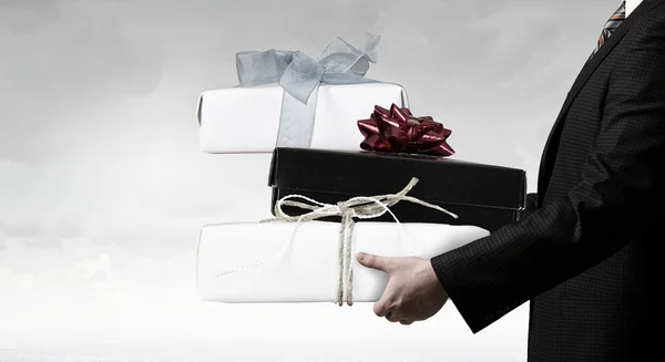 Businessman hold gift box . Mixed media — Stock Photo, Image