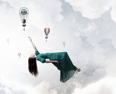 Gökyüzünde levitating kadın. Karışık teknik