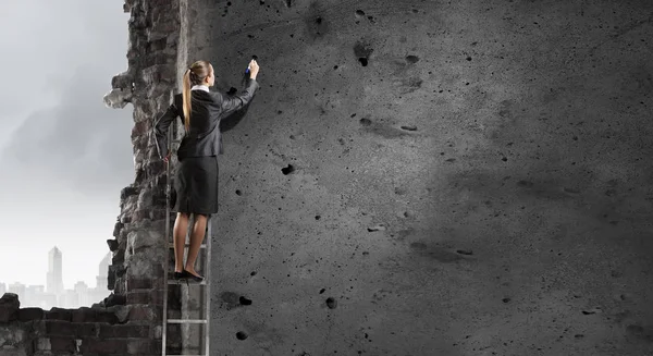 Une femme dessine sur un mur. Techniques mixtes — Photo