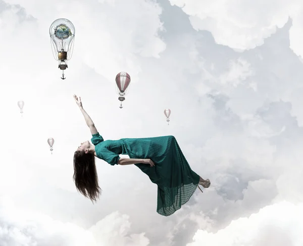 Woman levitating in sky . Mixed media — Stock Photo, Image