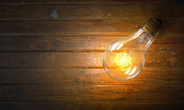 Ahşap yüzey üzerinde ampul. Karışık teknik