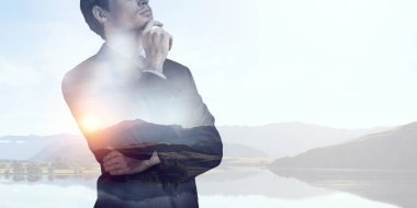 İşadamı doğa bir arka plana dayanır. Karışık teknik