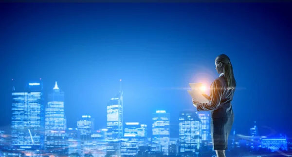 Vista trasera de la mujer de negocios mirando la ciudad nocturna. Medios mixtos — Foto de Stock