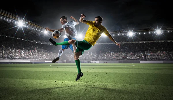 Fußballer kämpfen um den Ball. Gemischte Medien — Stockfoto